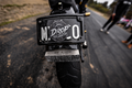 Titanium scrape block fitted below a motorcycle number plate